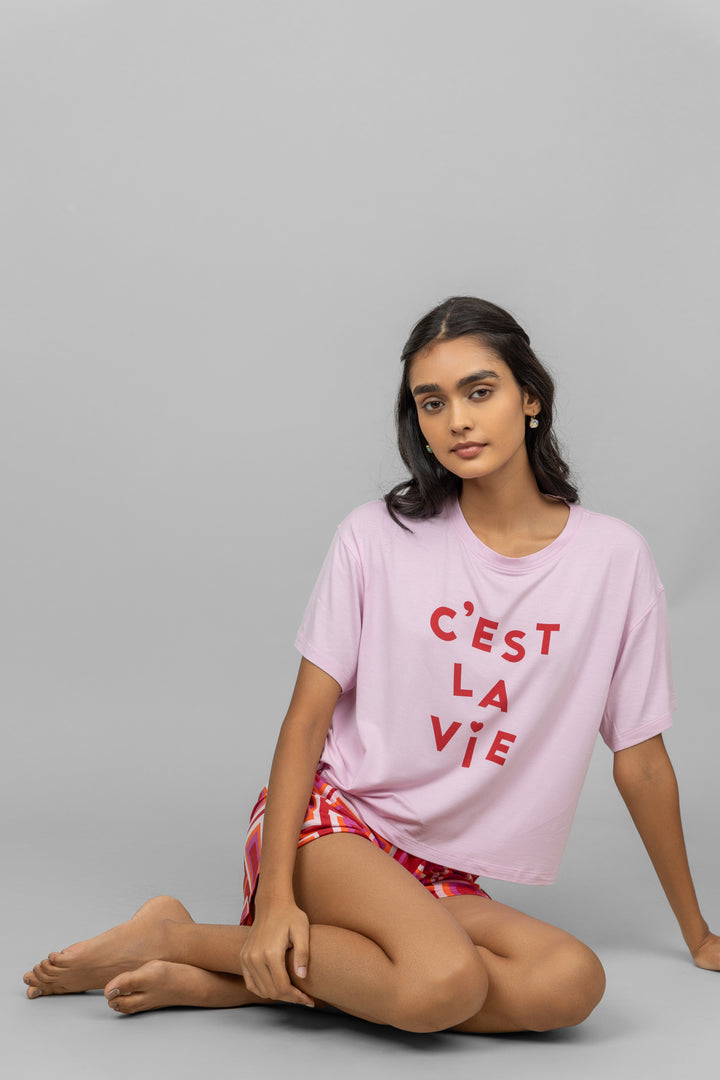 C'est La Vie pink shorts set model sitting stylishly.