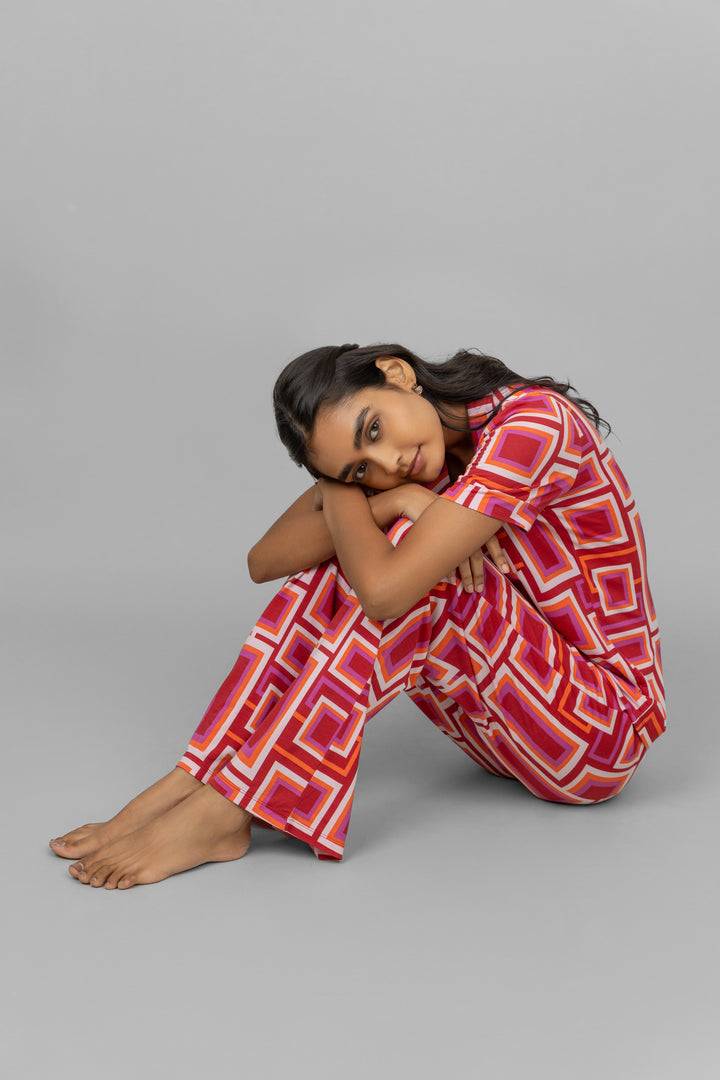 Model in stylish red Zen pajamas with geometric patterns.