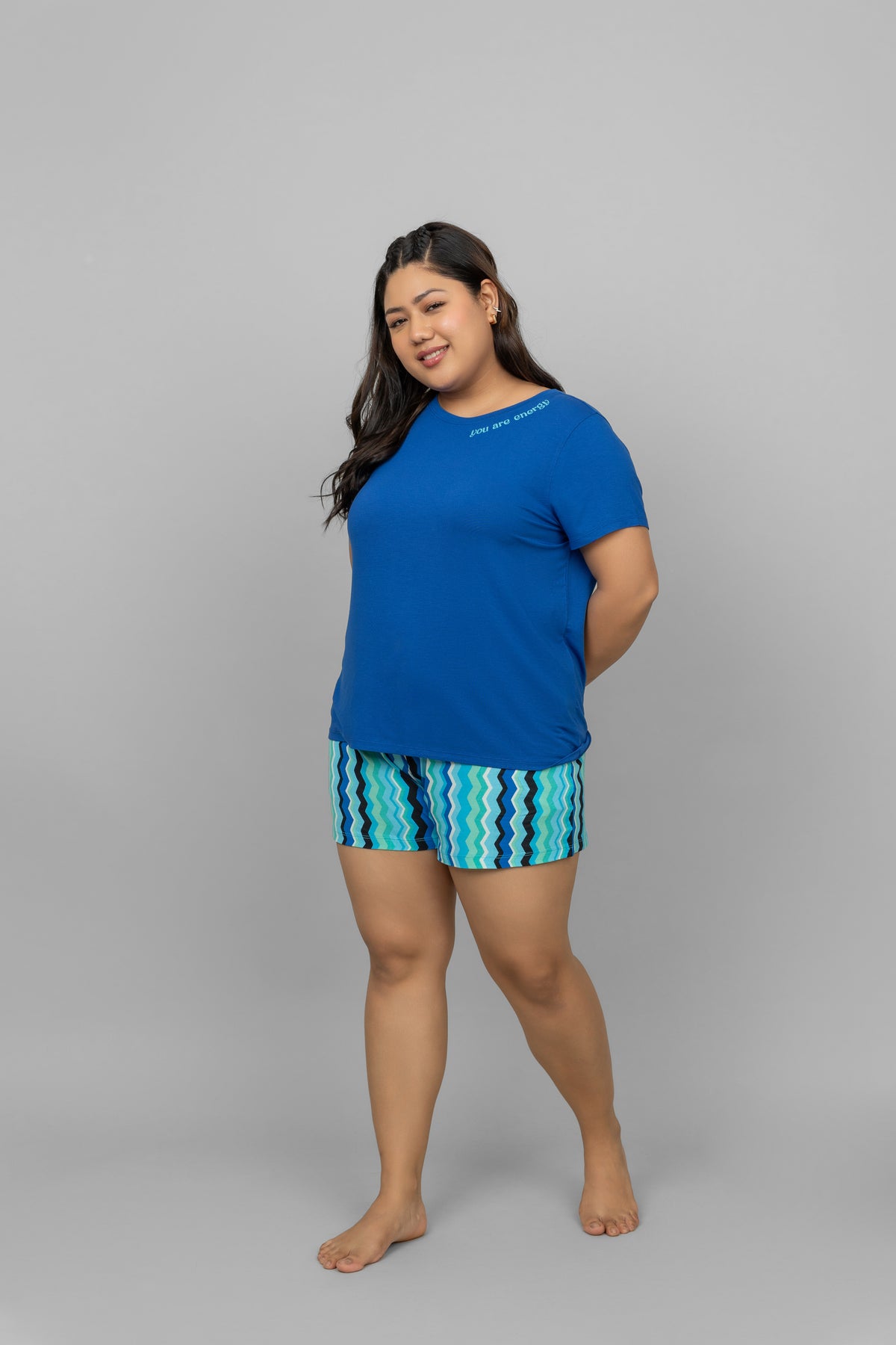 AquaWave Shorts worn with a blue top, showcasing vibrant wave patterns.