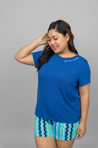"Model wearing blue 'You Are Energy' T-shirt with patterned shorts."