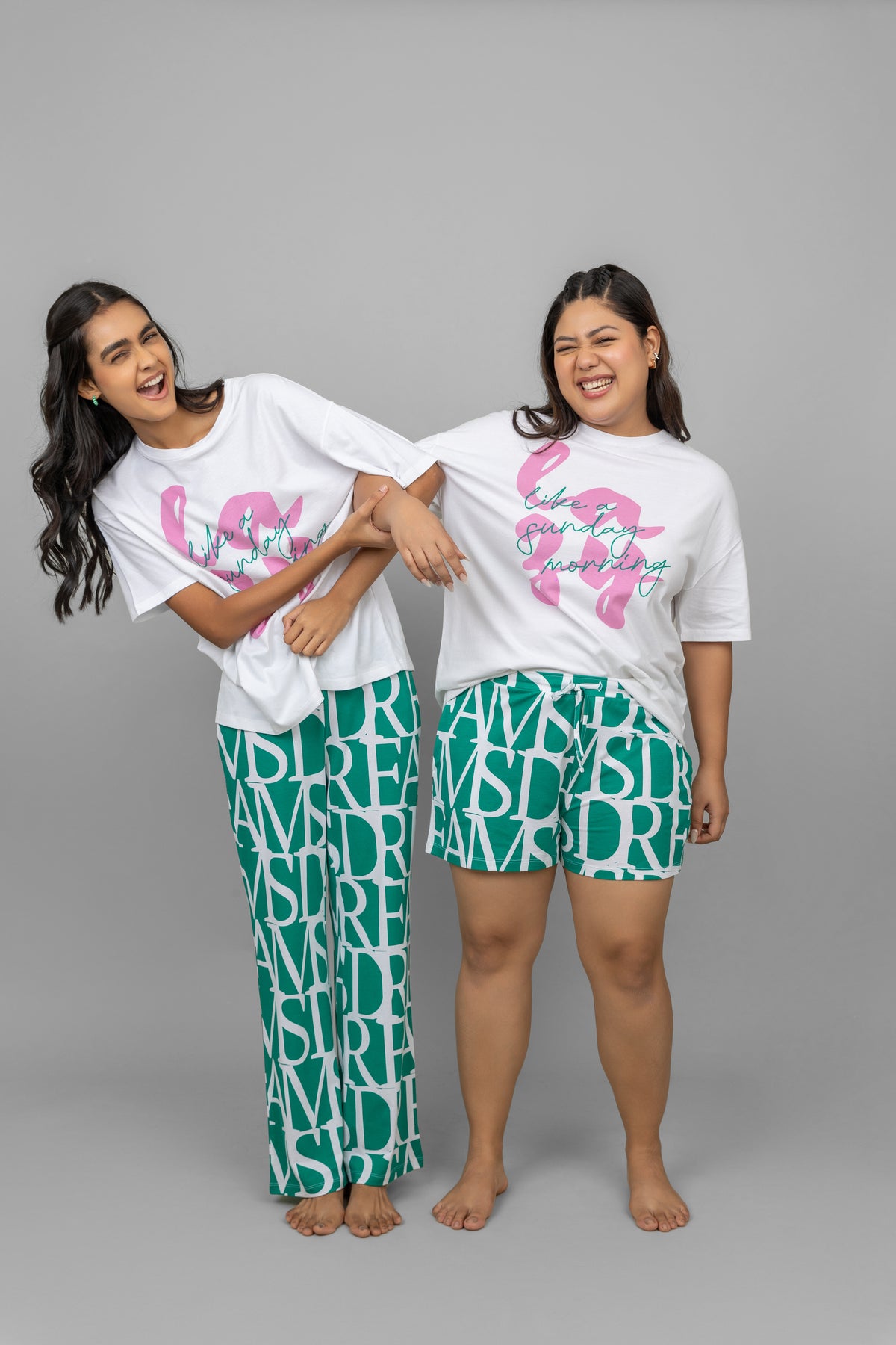 White oversized lazy top worn by two smiling women.