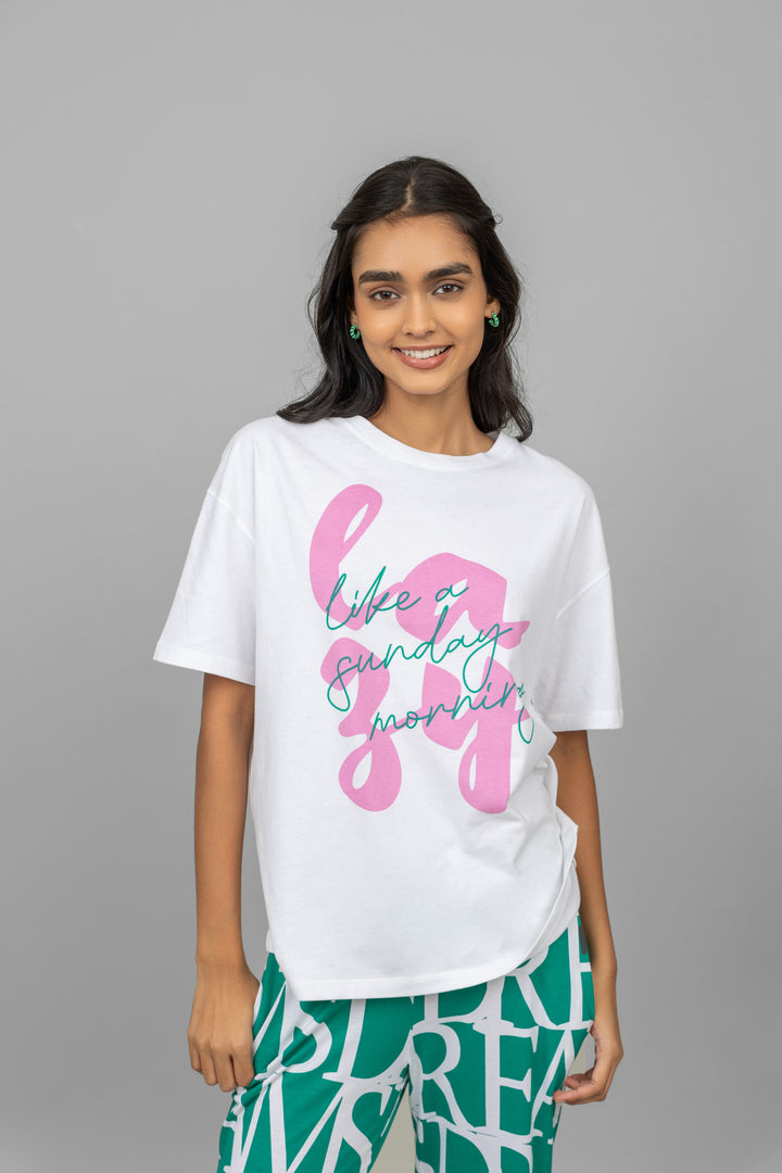 Model wearing a white oversized lazy top with graphic design.