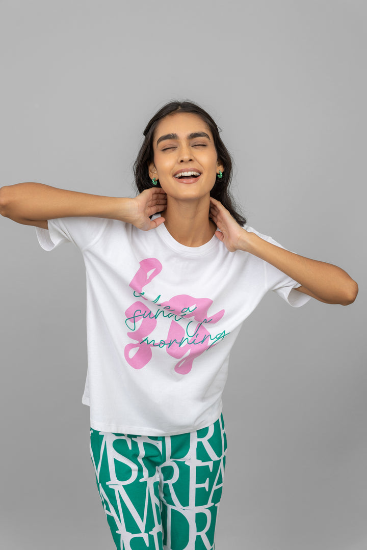 Happy model wearing a white oversized lazy top with vibrant graphics.