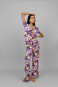 Floral half sleeves button-down pajama set on model, vibrant colors and patterns.