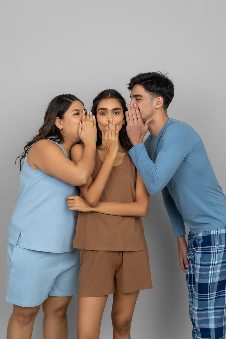 Home brown lounge shorts set worn by playful models against a gray background.