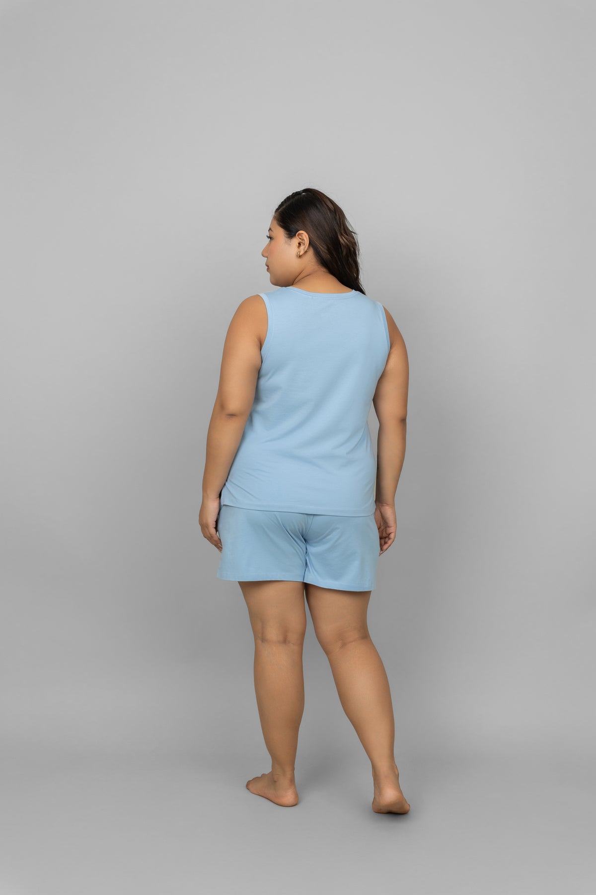 Blue cotton tank top worn with matching shorts, back view.