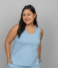 Blue cotton tank top on a smiling model against a gray background.