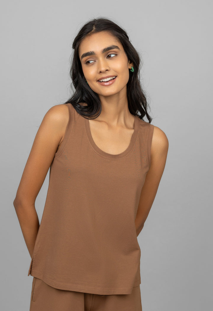 Model wearing a stylish home brown tank top, smiling.