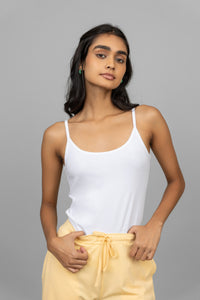 Stylish woman wearing a white vest with yellow pants.