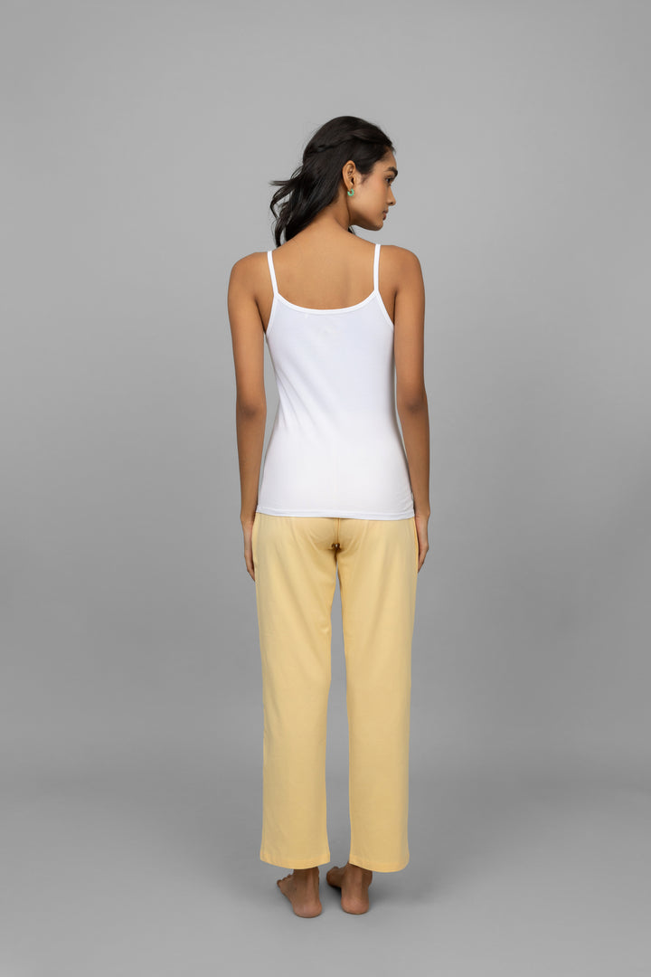 Back view of a woman wearing a white vest and yellow pants.