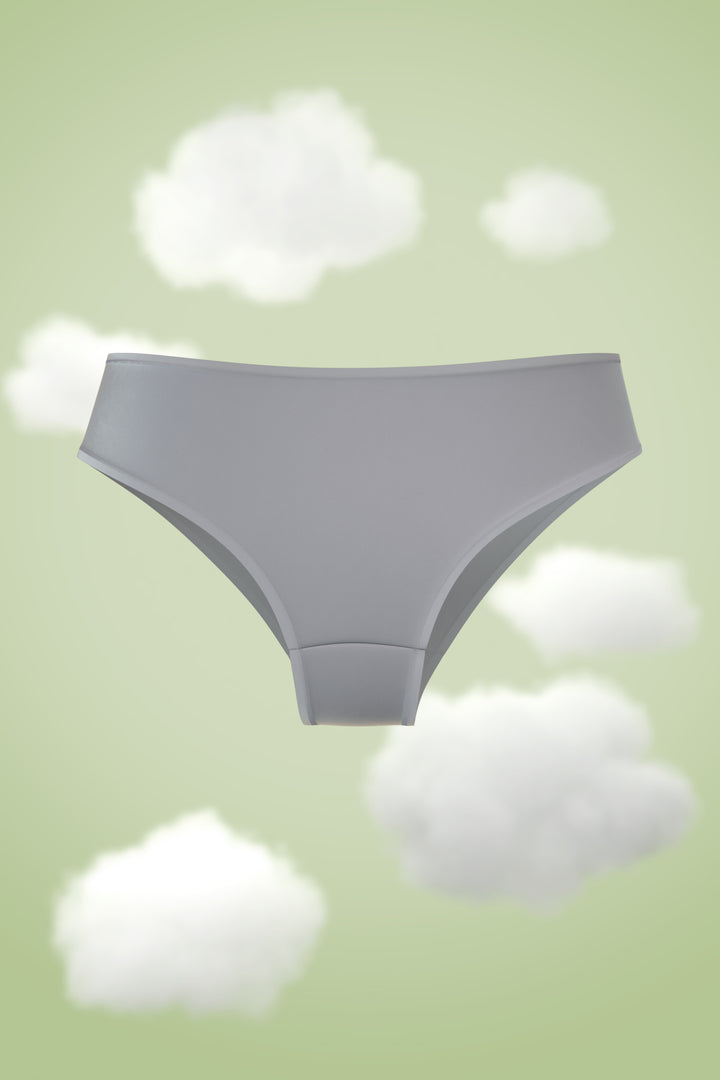 Supima Hipster Nessies in soft gray against a pastel cloud background.