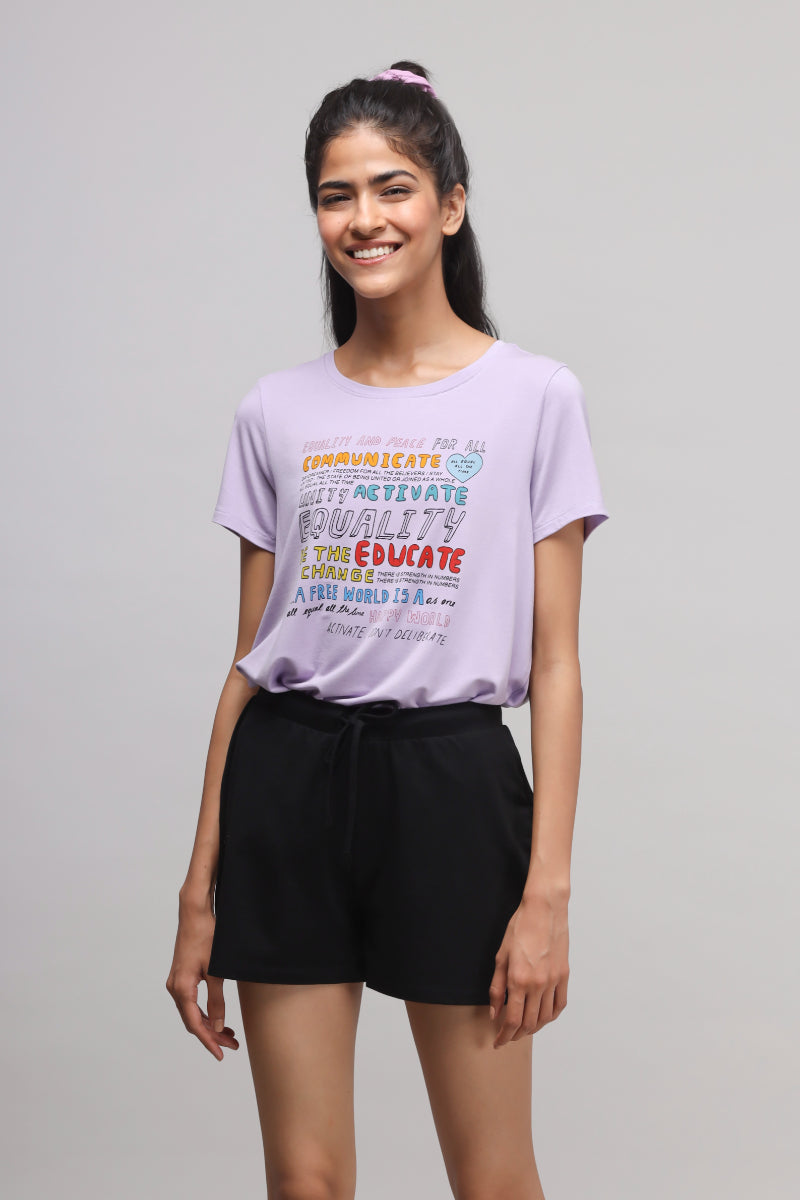 Woman wearing Equality Purple Top with positive graphic design.