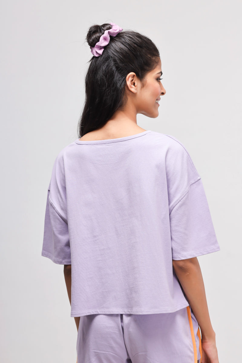 Back view of a boxy purple cotton top for women.