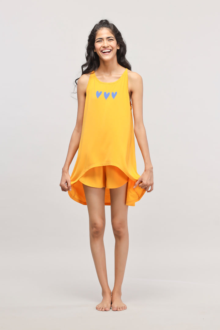 Bright orange Butterfly Mango tank top with heart design, modeled by a smiling woman.