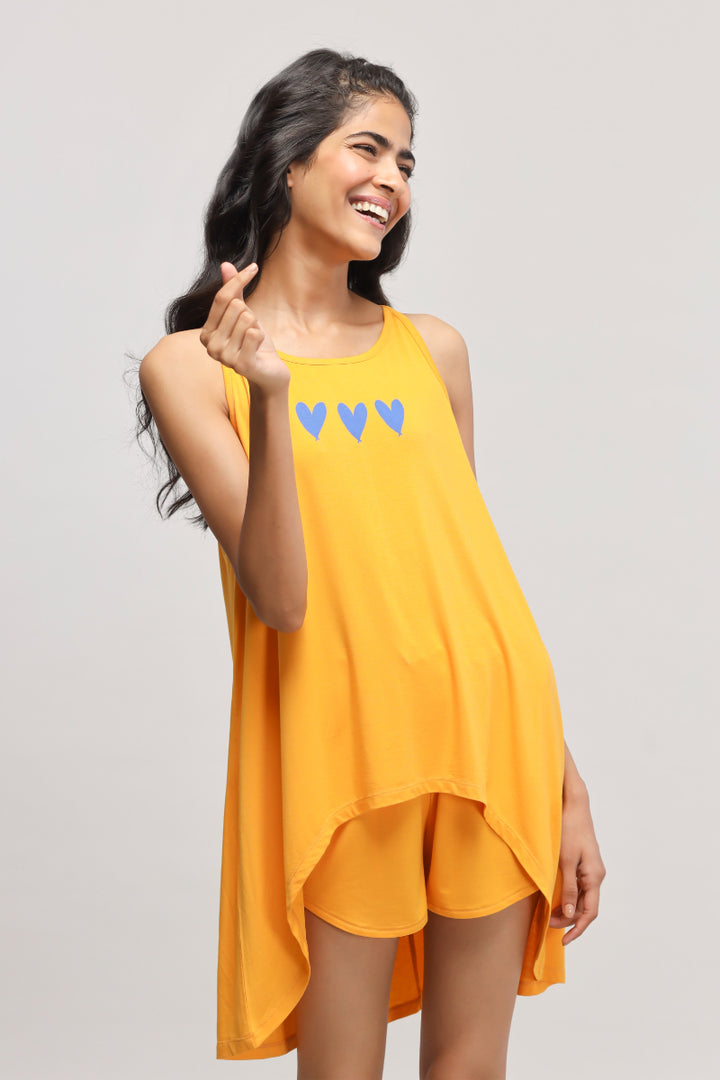Smiling model showcases stylish Butterfly Mango Shorts in vibrant yellow.