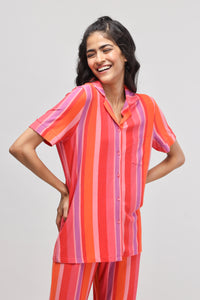 Model wearing a vibrant red striped top with pink accents.
