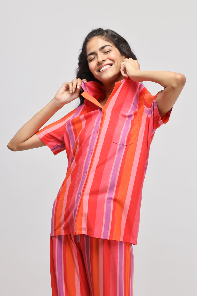 Woman wearing a stylish red striped top and smiling.