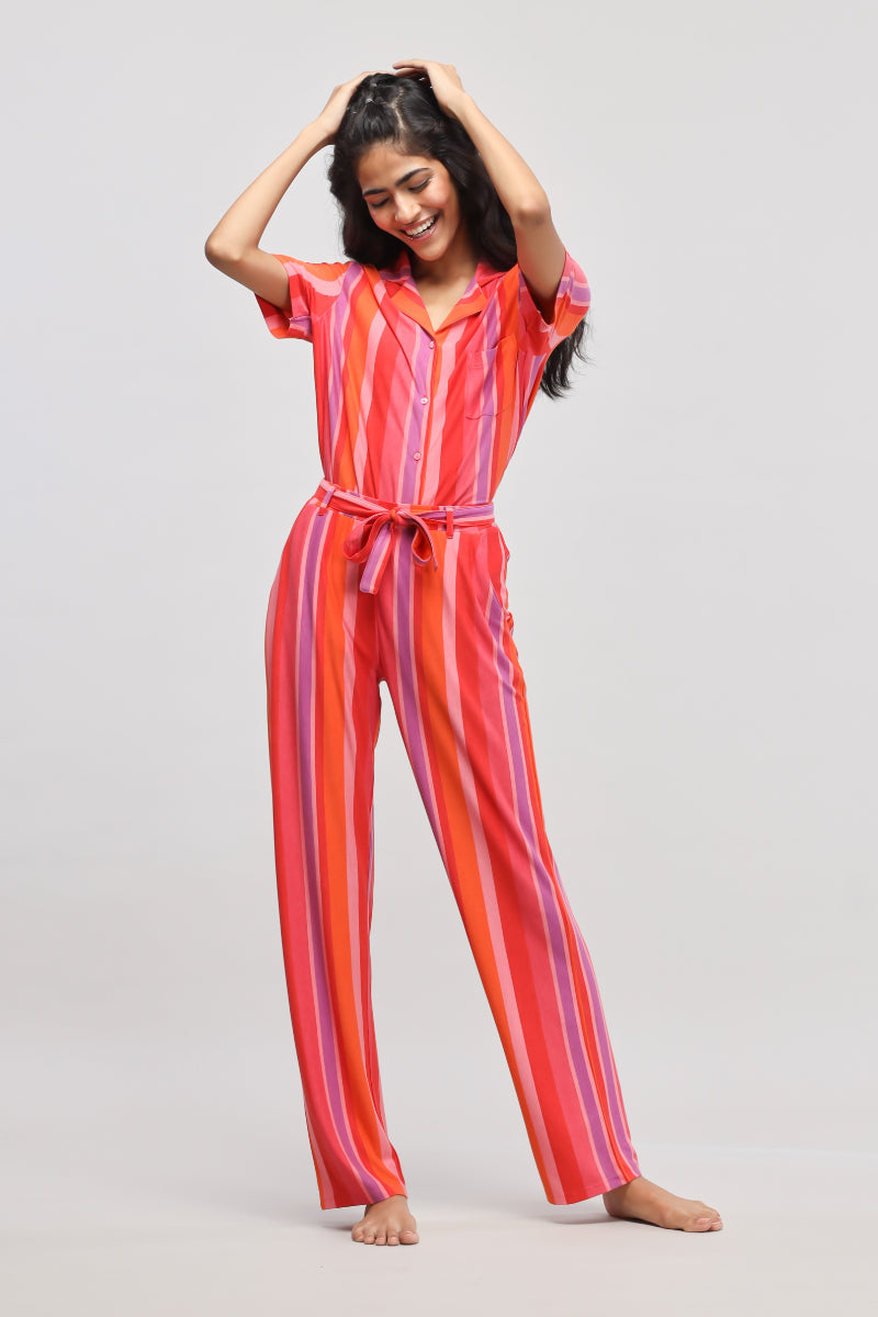 Colorful red stripe pajama set worn by a smiling woman.