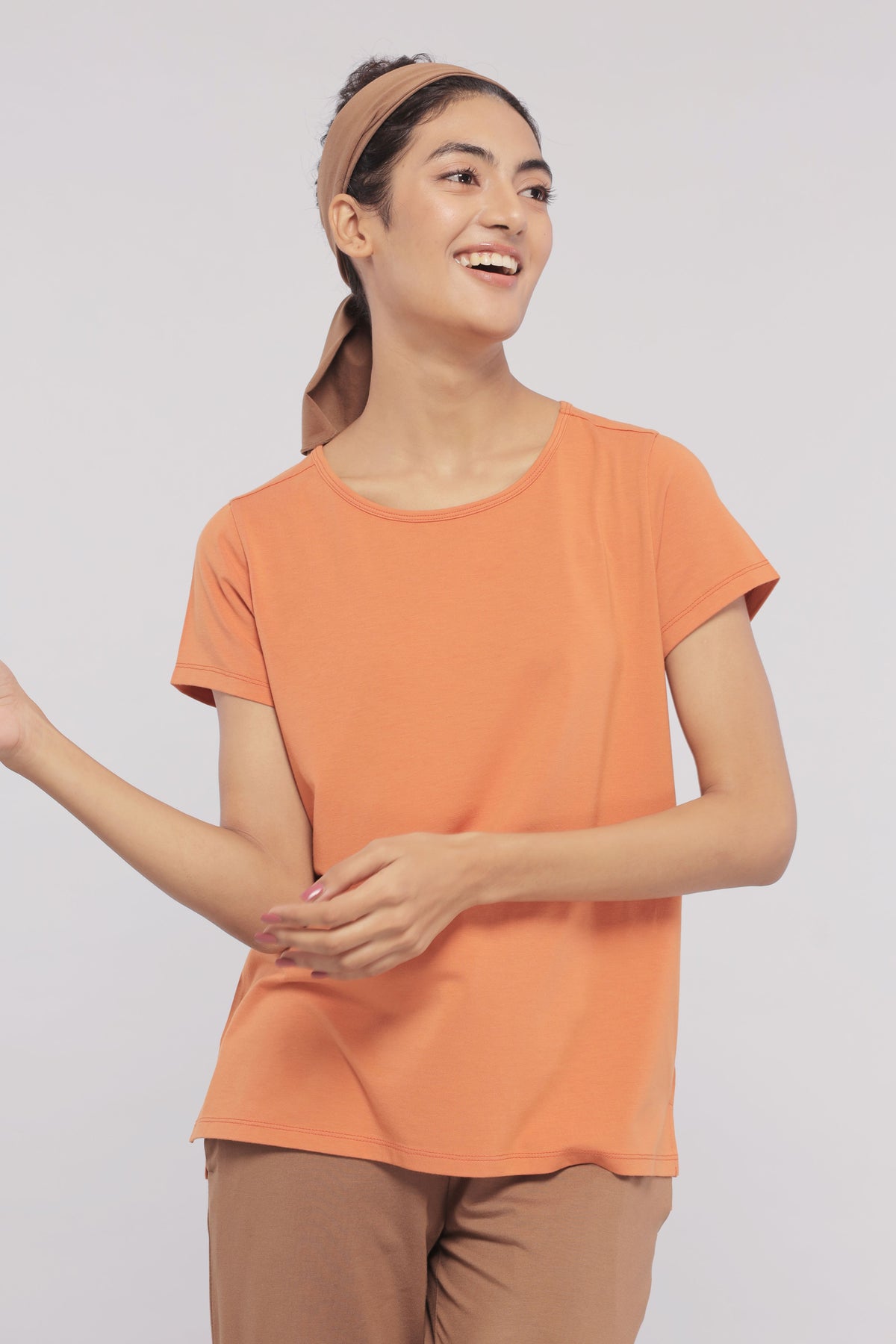 Golden Ochre Supima® Round Neck Tee on a smiling model.