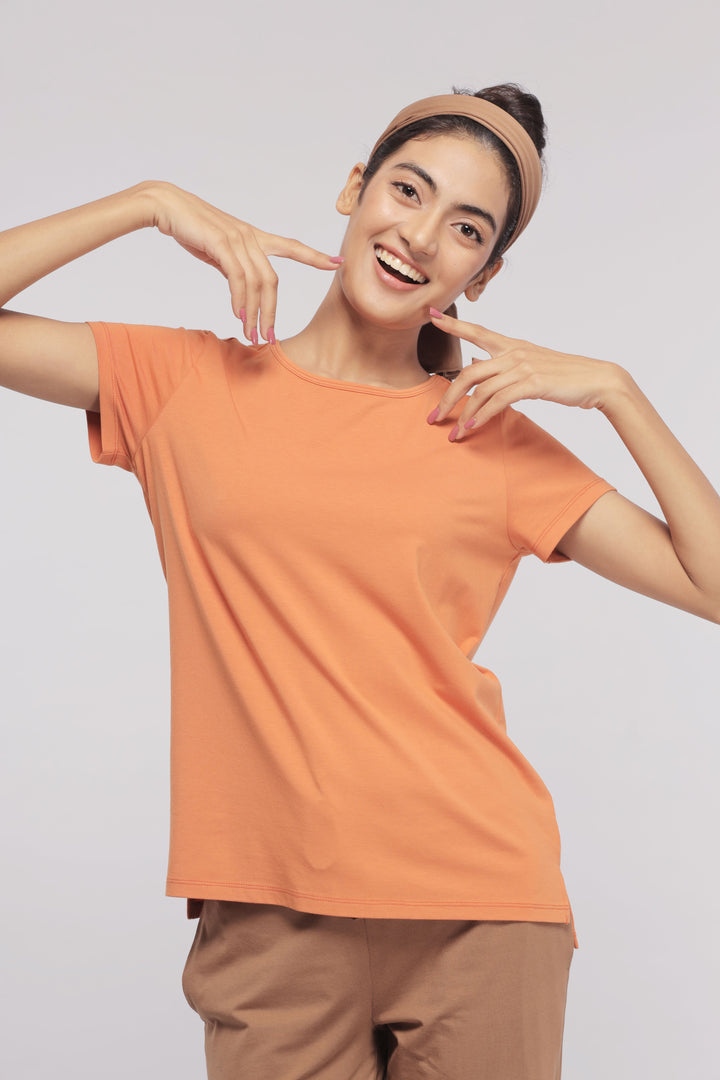 Smiling woman in brown flared lounge set, perfect for home wear.