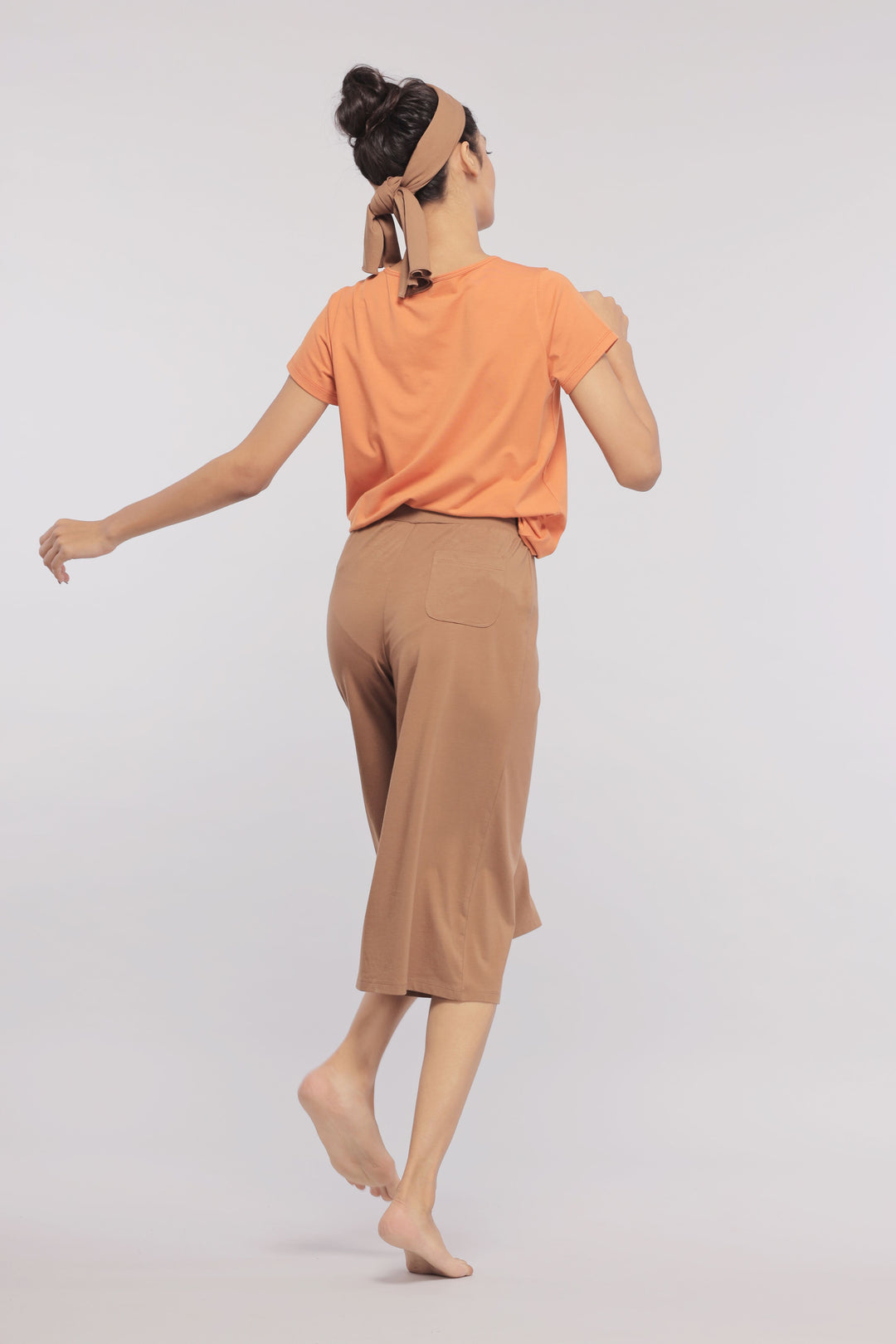 Model wearing Golden Ochre Supima V Neck Tee with brown culottes.