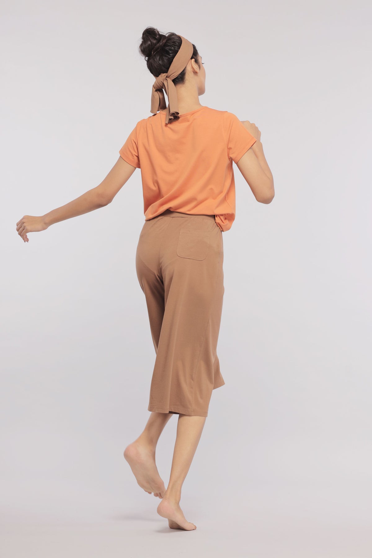 Model wearing brown Supima® culottes with orange top, stylish and comfortable.