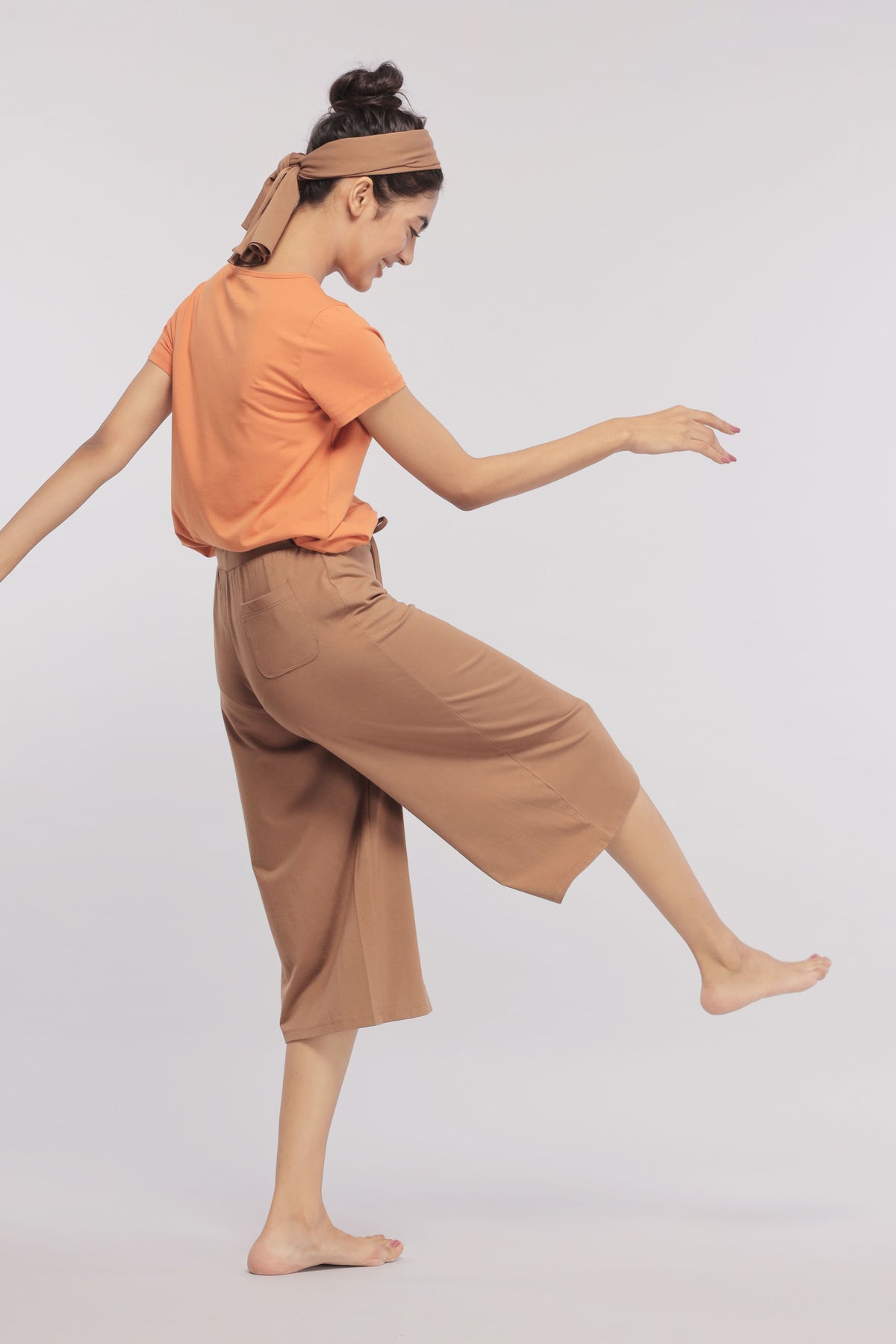 Home brown Supima® culottes worn by a model in playful pose.
