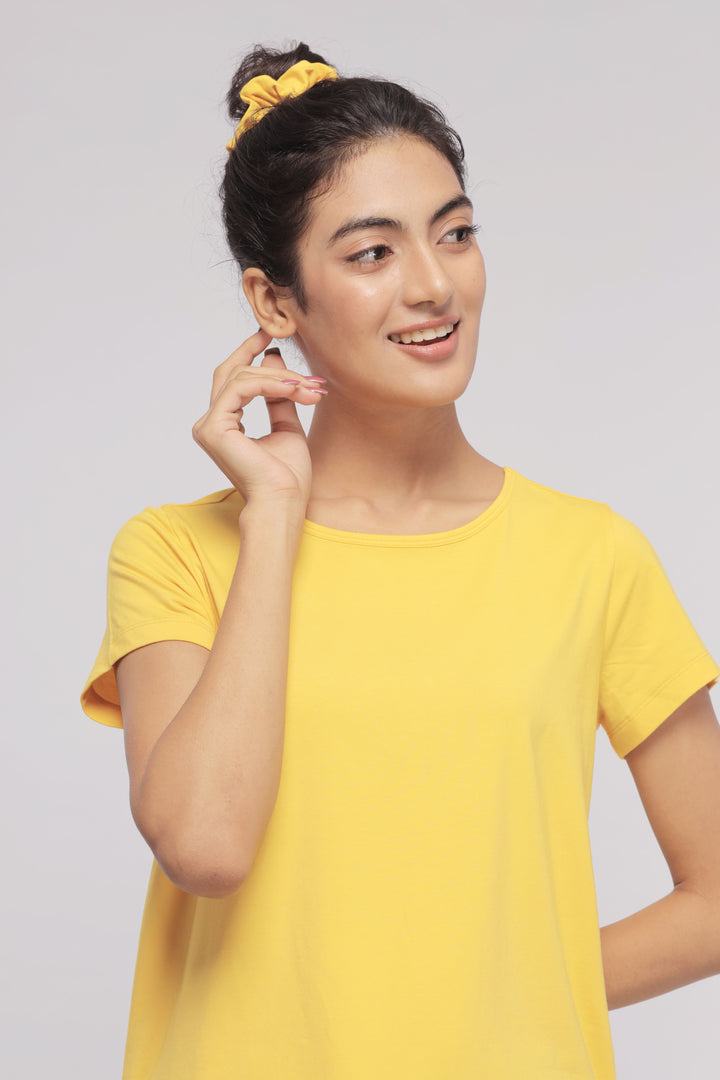 Smiling woman in yellow shirt showcasing Sunny Lime Supima® Lounge Set.