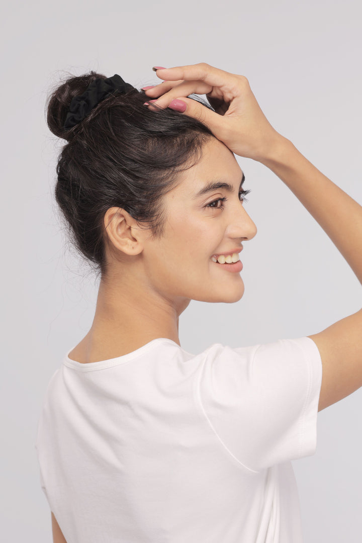 Woman smiling while wearing a white Supima® tee, showcasing casual style.