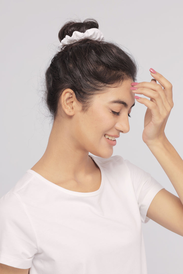 "Model wearing White Supima® Women Tee with a stylish hair bun."