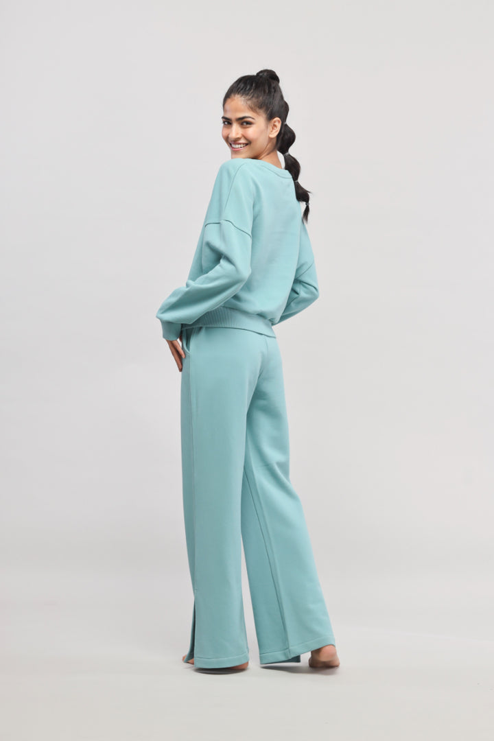 Woman in turquoise Bonjour Terry Co-ord Set smiling and posing.