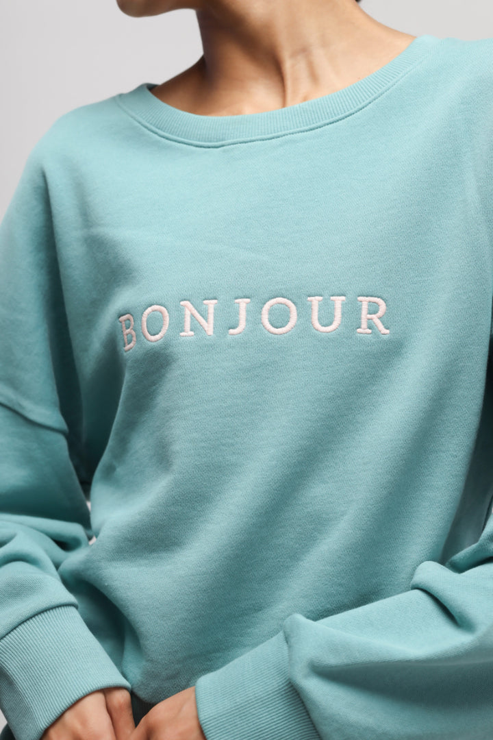 Turquoise Bonjour Terry Sweatshirt with embroidered lettering detail.