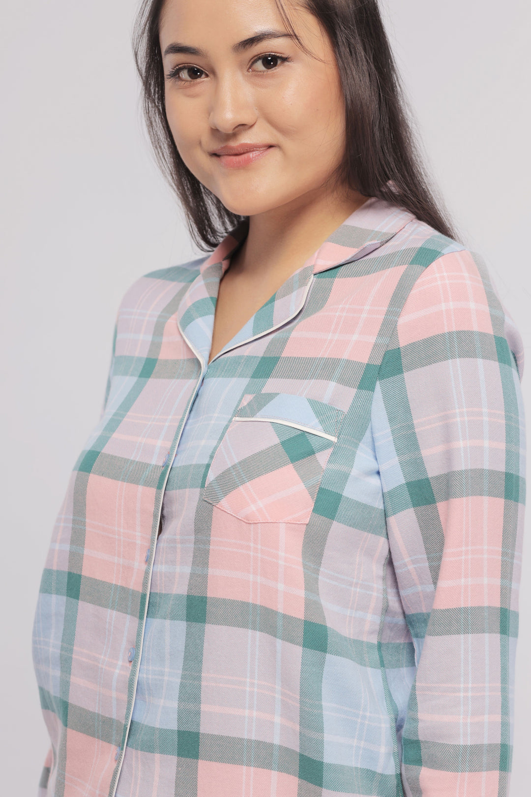 Woman modeling a pink and blue plaid flannel pajama set.