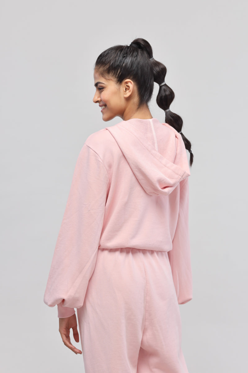 Model wearing a stylish pink terry hoodie from the back.