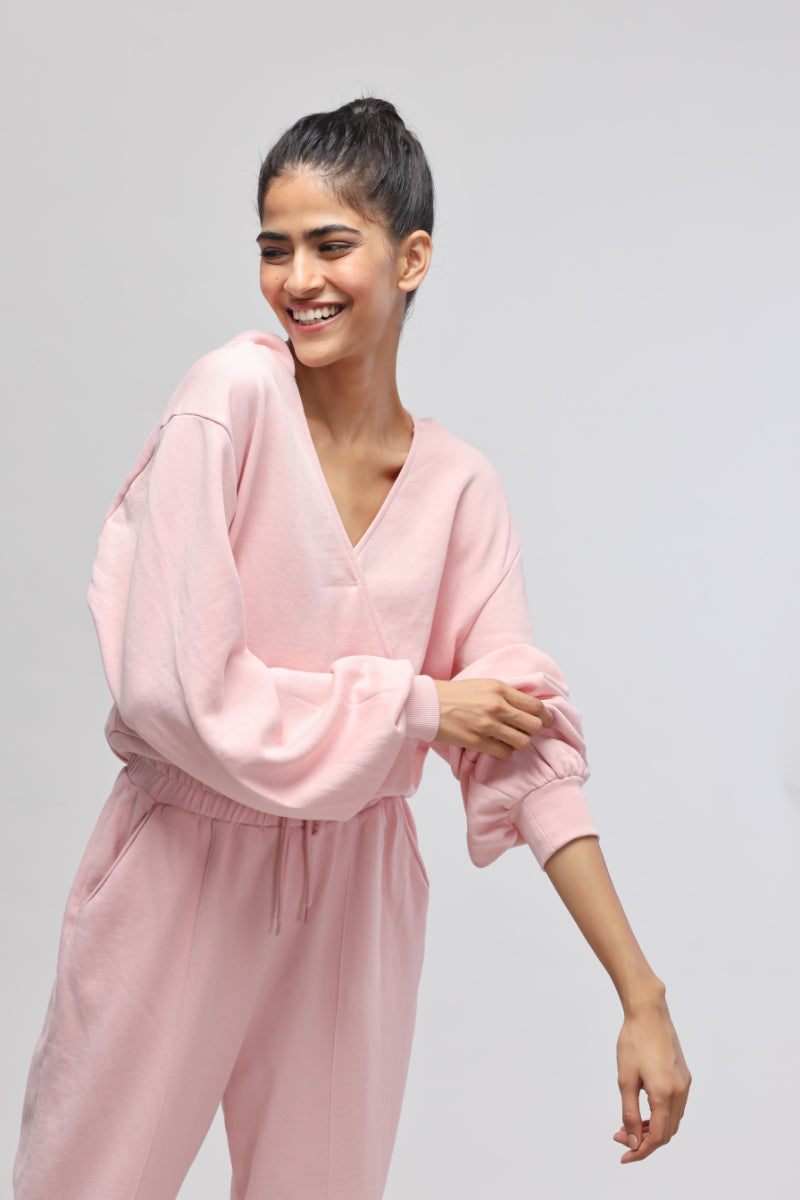 Smiling woman in a pink terry hoodie, showcasing casual style.