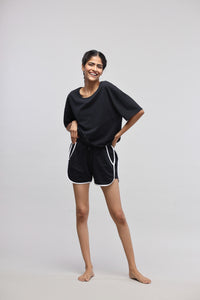 Boxy black cotton shorts set modeling on a light background.
