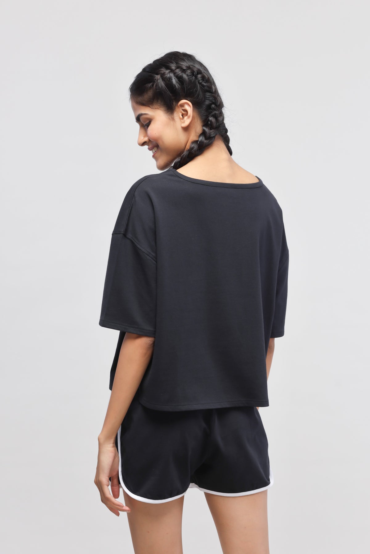 Boxy black cotton top stylishly worn with black shorts.