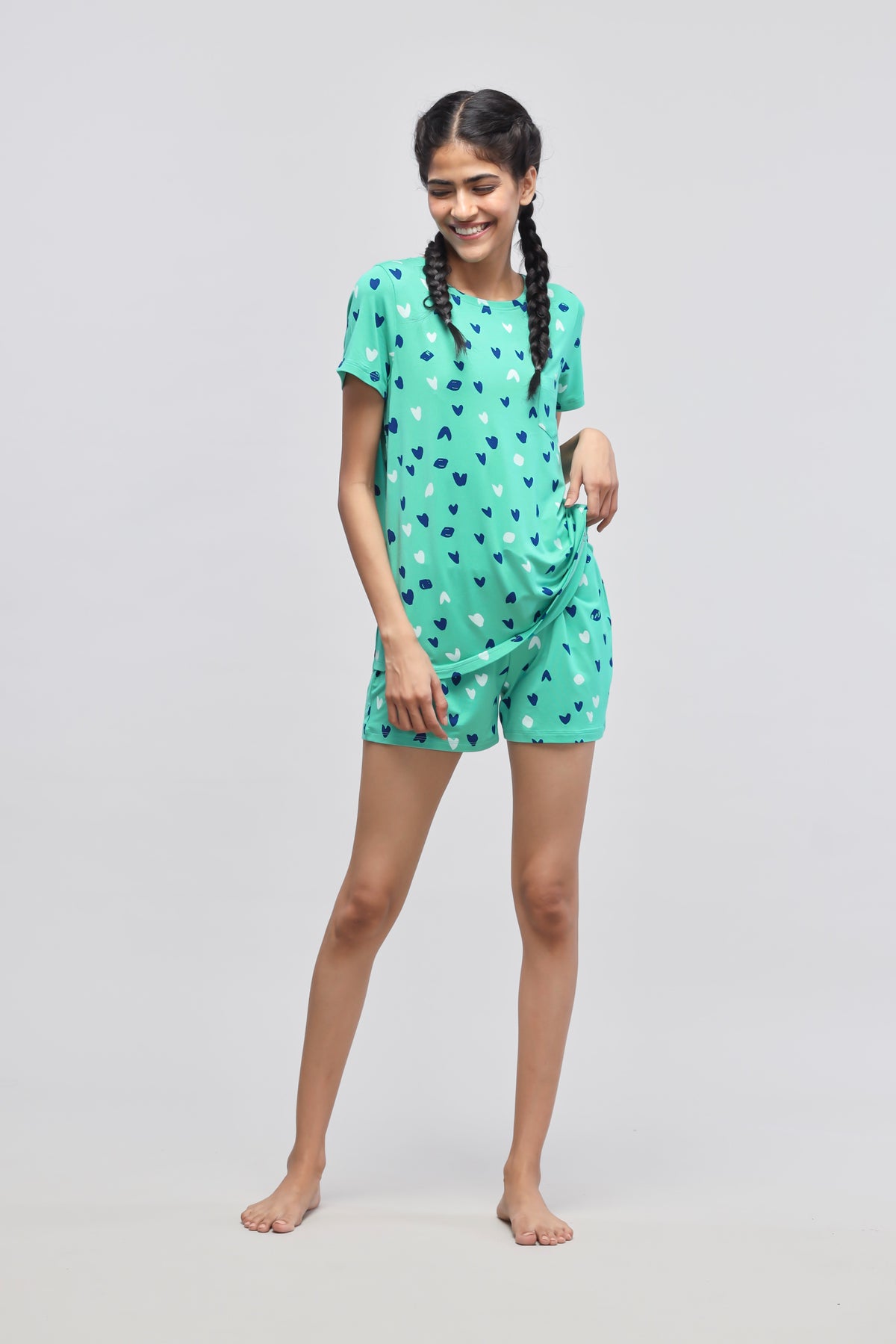 "Model wearing Heartsy Shorts in green with heart print design."
