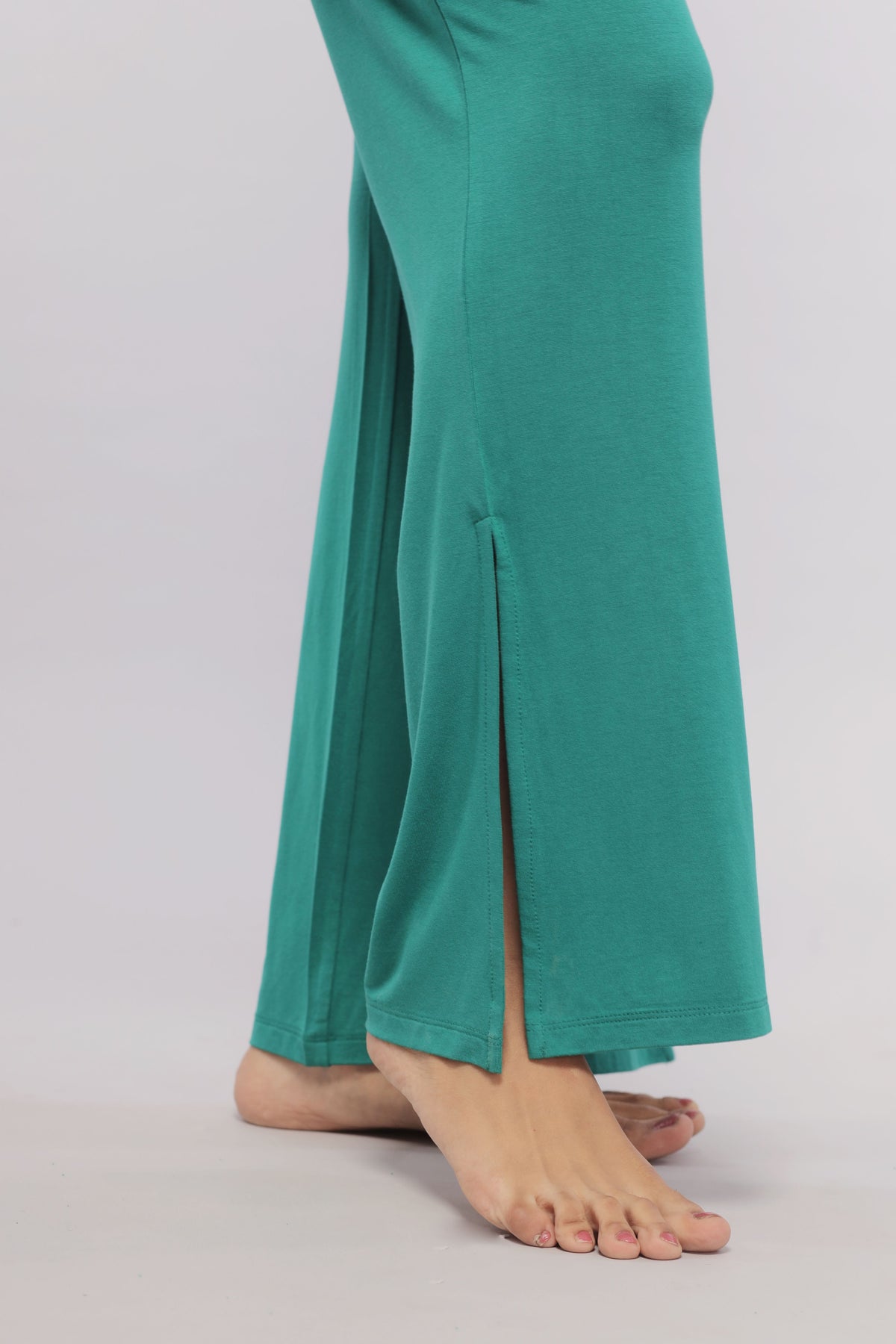Green flared lounge pants featuring stylish side slits and comfortable fit.