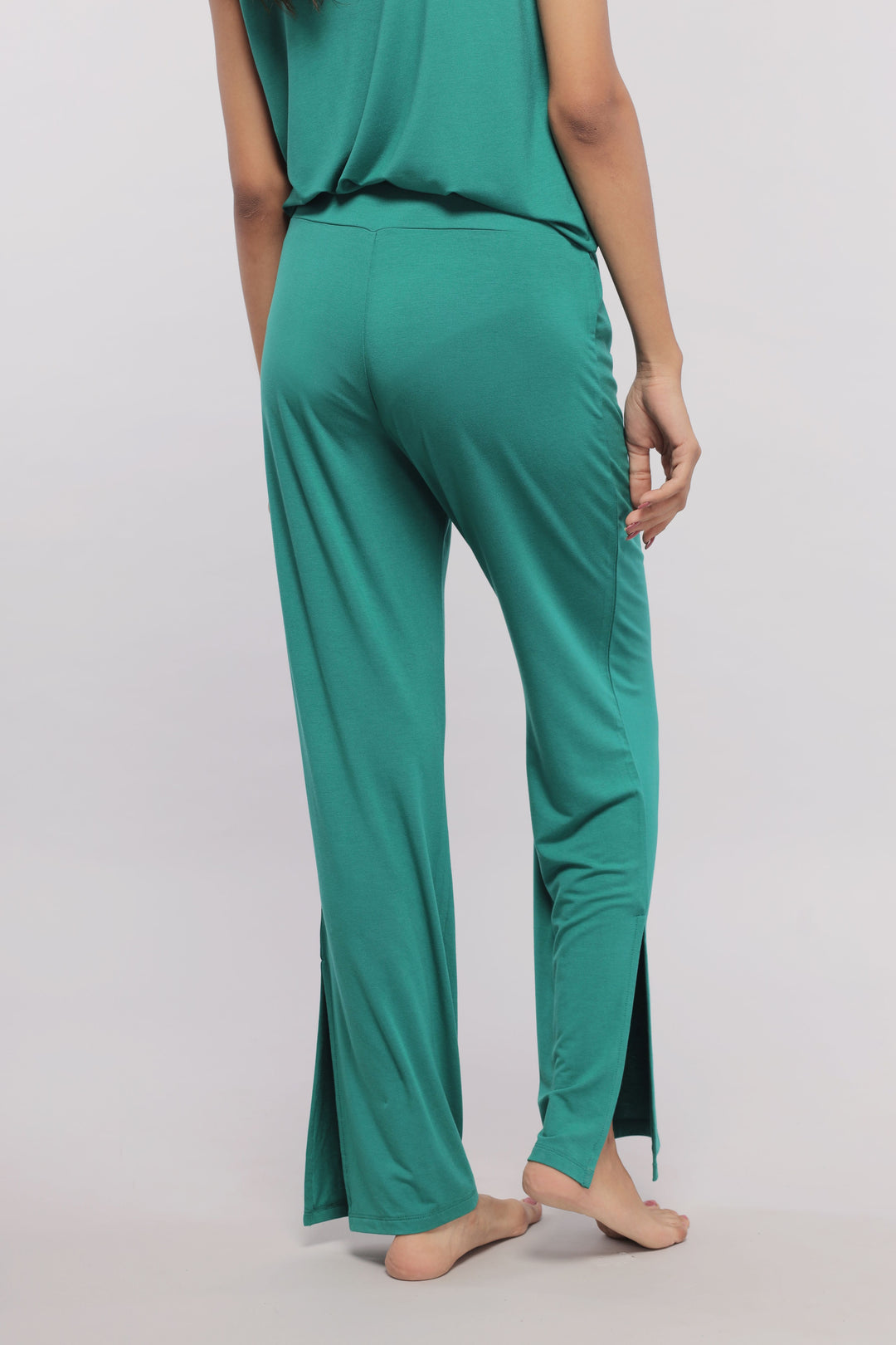 Green flared lounge pants with stylish side slits, perfect for casual wear.