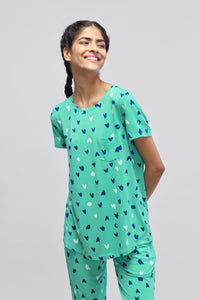 Smiling model wearing Heartsy Top with heart pattern design.