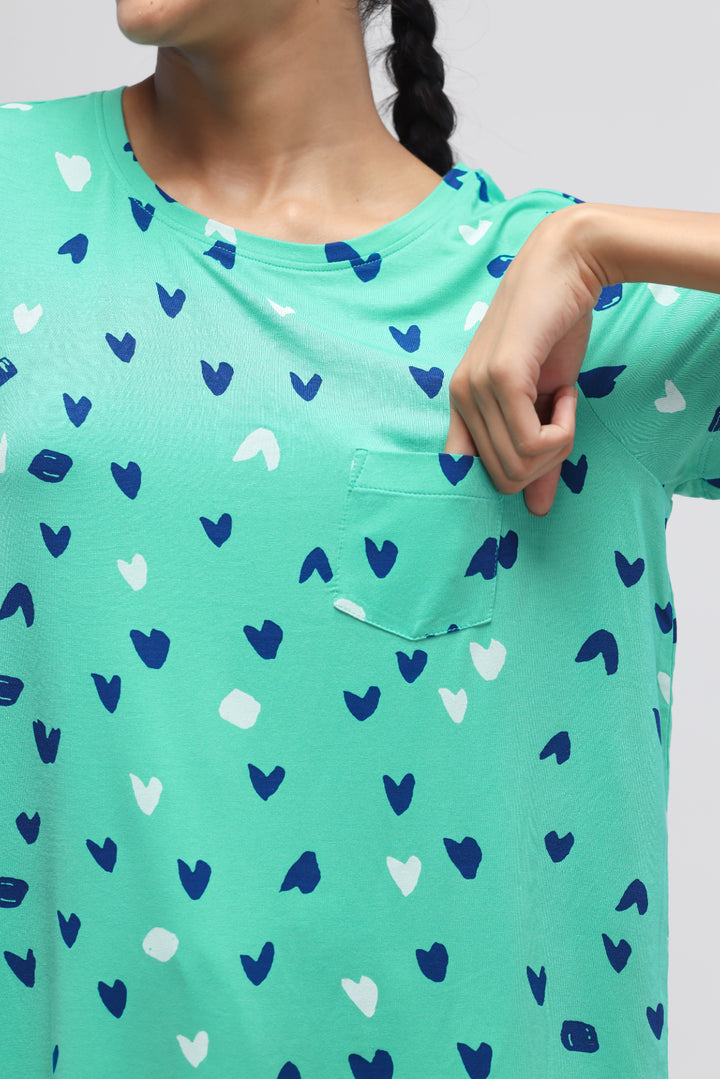 Heartsy Top featuring playful heart patterns on a vibrant green background.