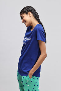 Model wearing "Snuggle is real" blue top with playful pants.