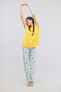 Cheerful girl in Voyager Cuffed Pajama Set, yellow top, playful pants.