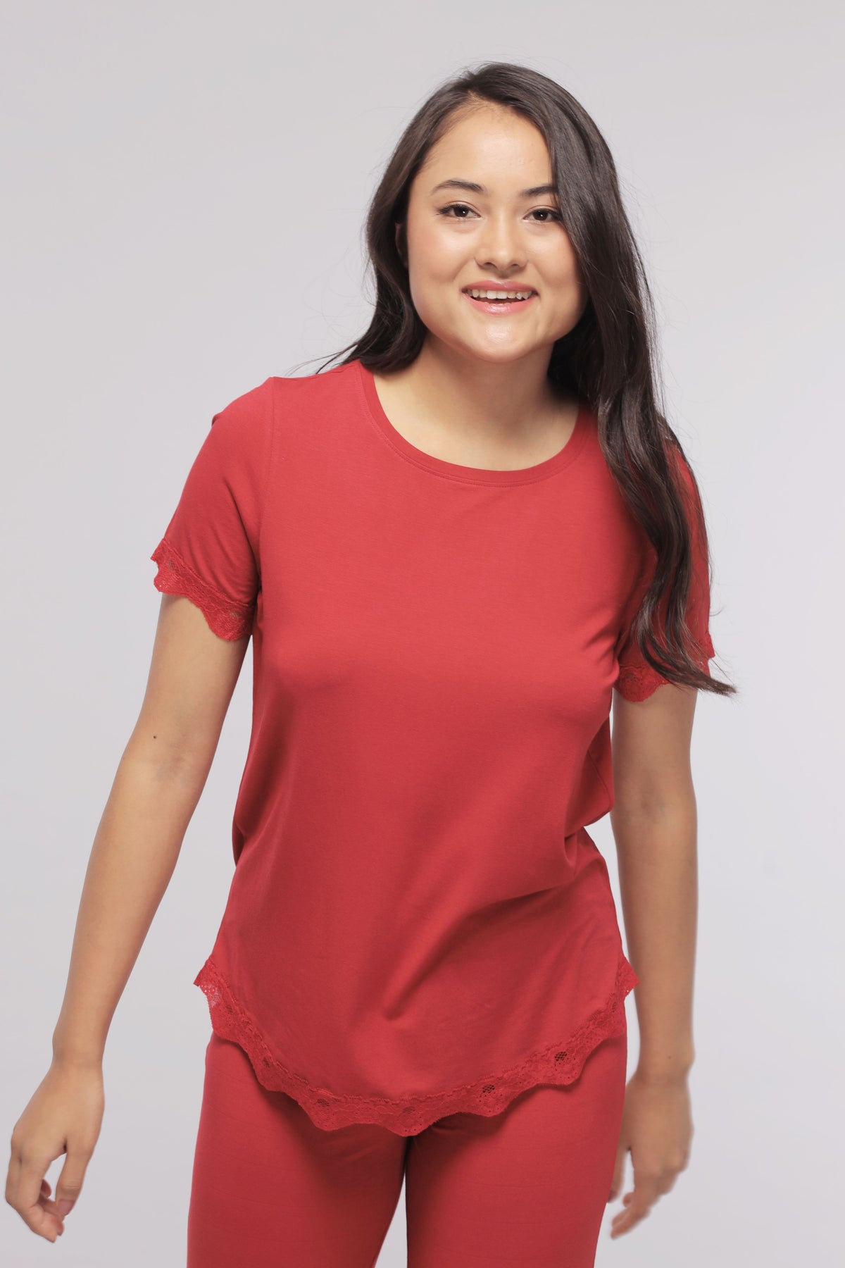 Romantic red lace top featuring stylish scalloped edges.