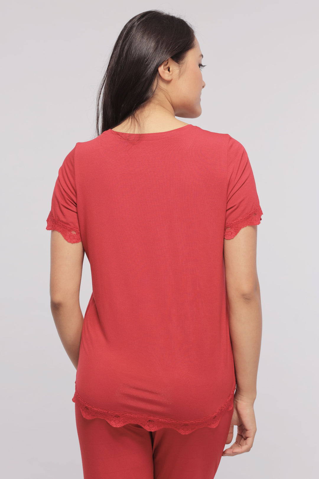 Back view of a woman wearing a romantic red lace top.