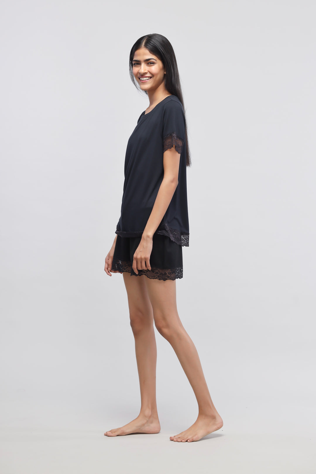 Delicate black lace shorts set model posing gracefully.