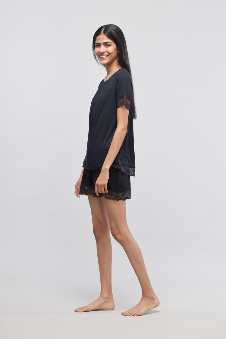 Delicate black lace shorts set model posing gracefully.