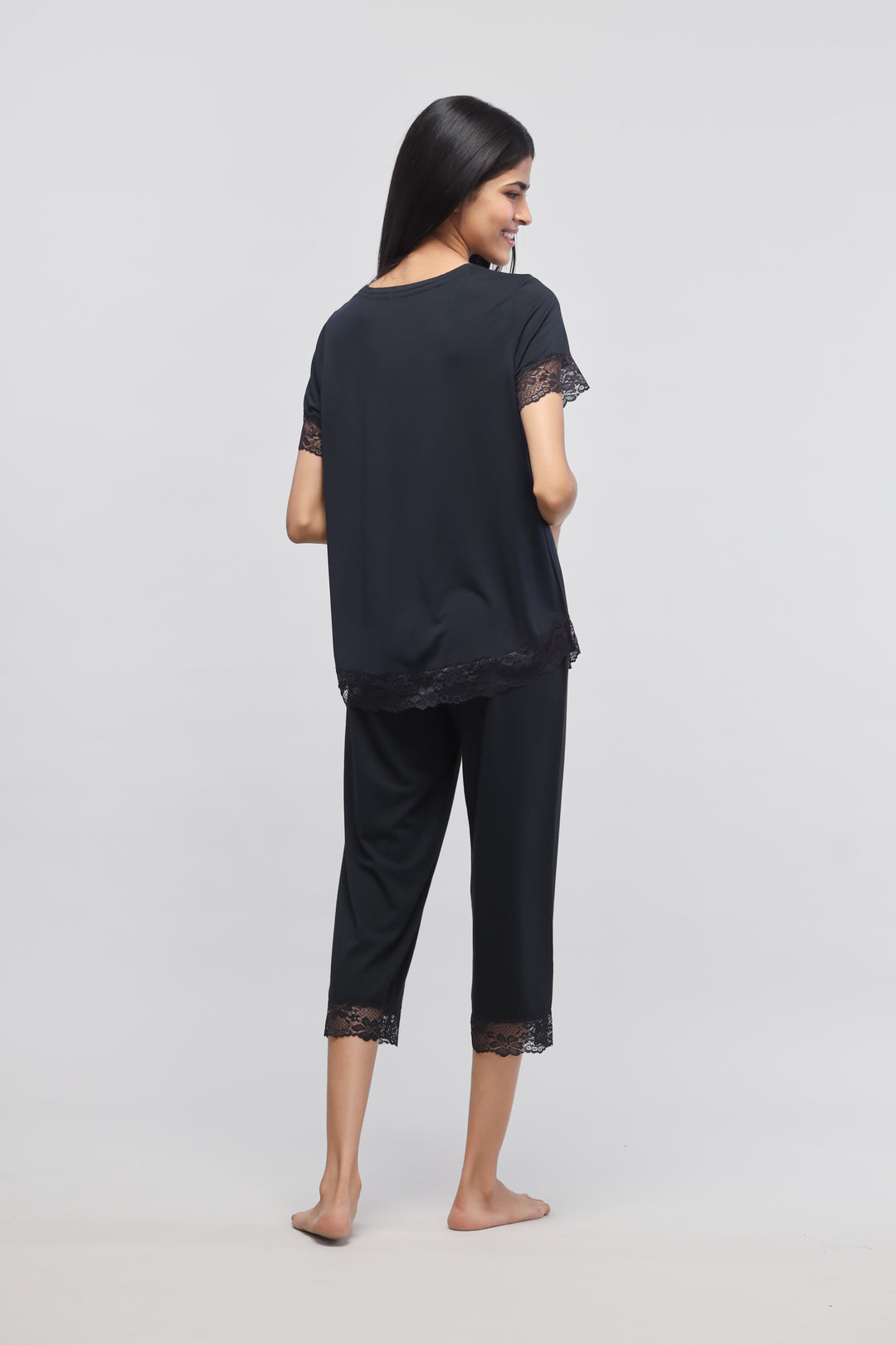 Delicate black lace top worn with matching pants, stylish and elegant look.