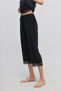 Delicate black lace capri pants styled for elegance and comfort.